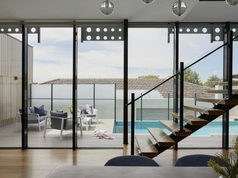 Sala com escada e portas de vidro para o terraço