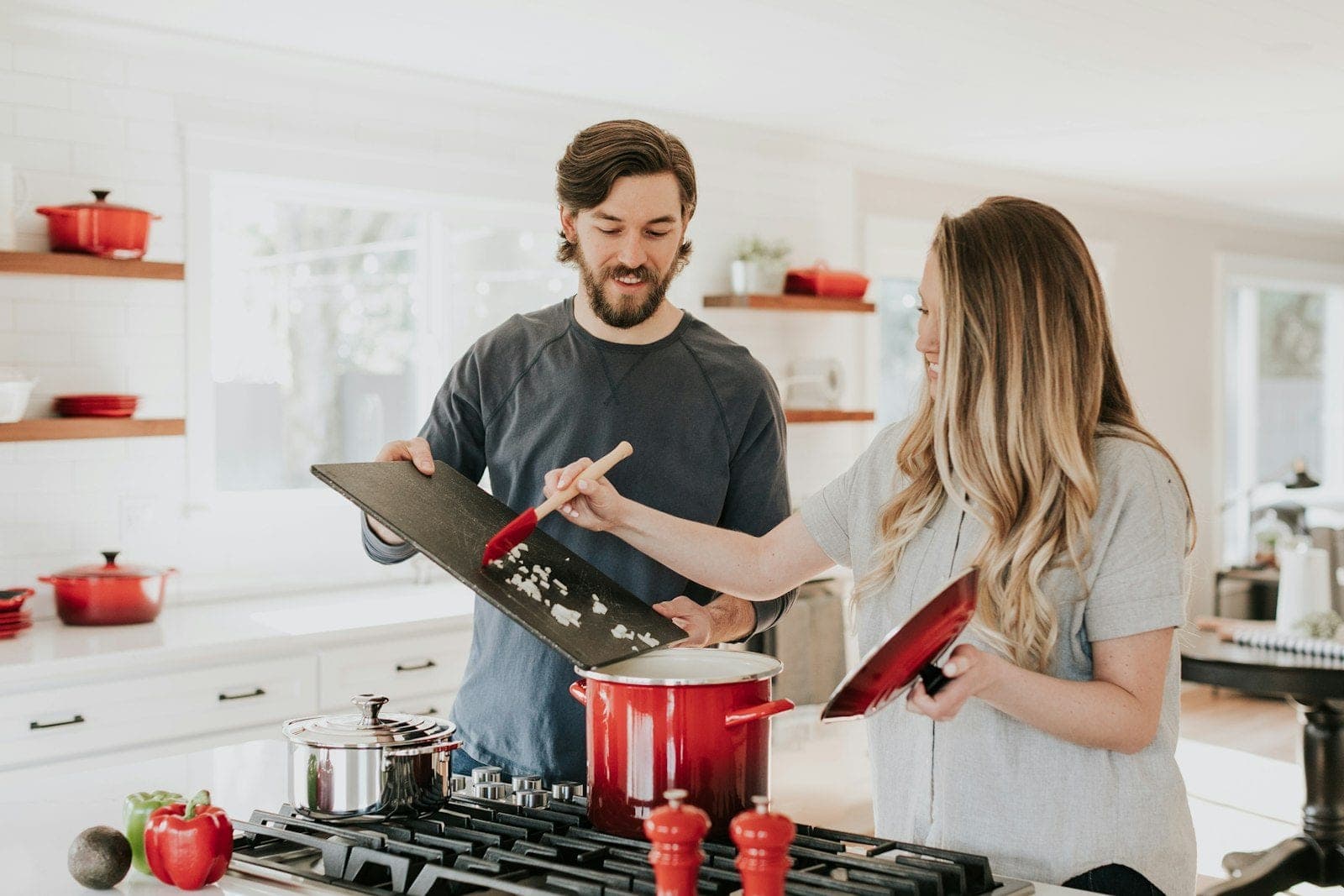 Casal cozinhando junto em casa nova
